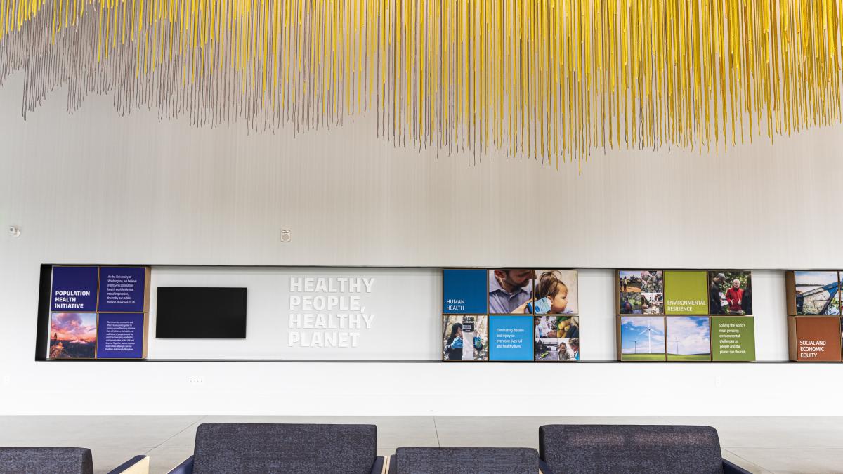 Wall with text that says "healthy people healthy planet" with dangling yellow fixture above