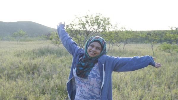 woman smiling and raising arms