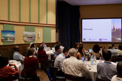 people sitting at tables viewing a screen that reads "welcome"