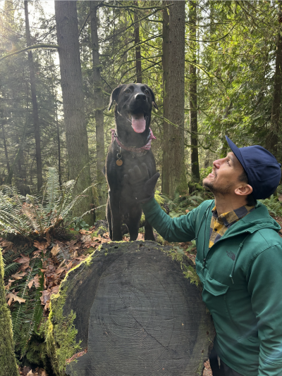 Man and a dog posing in the woods